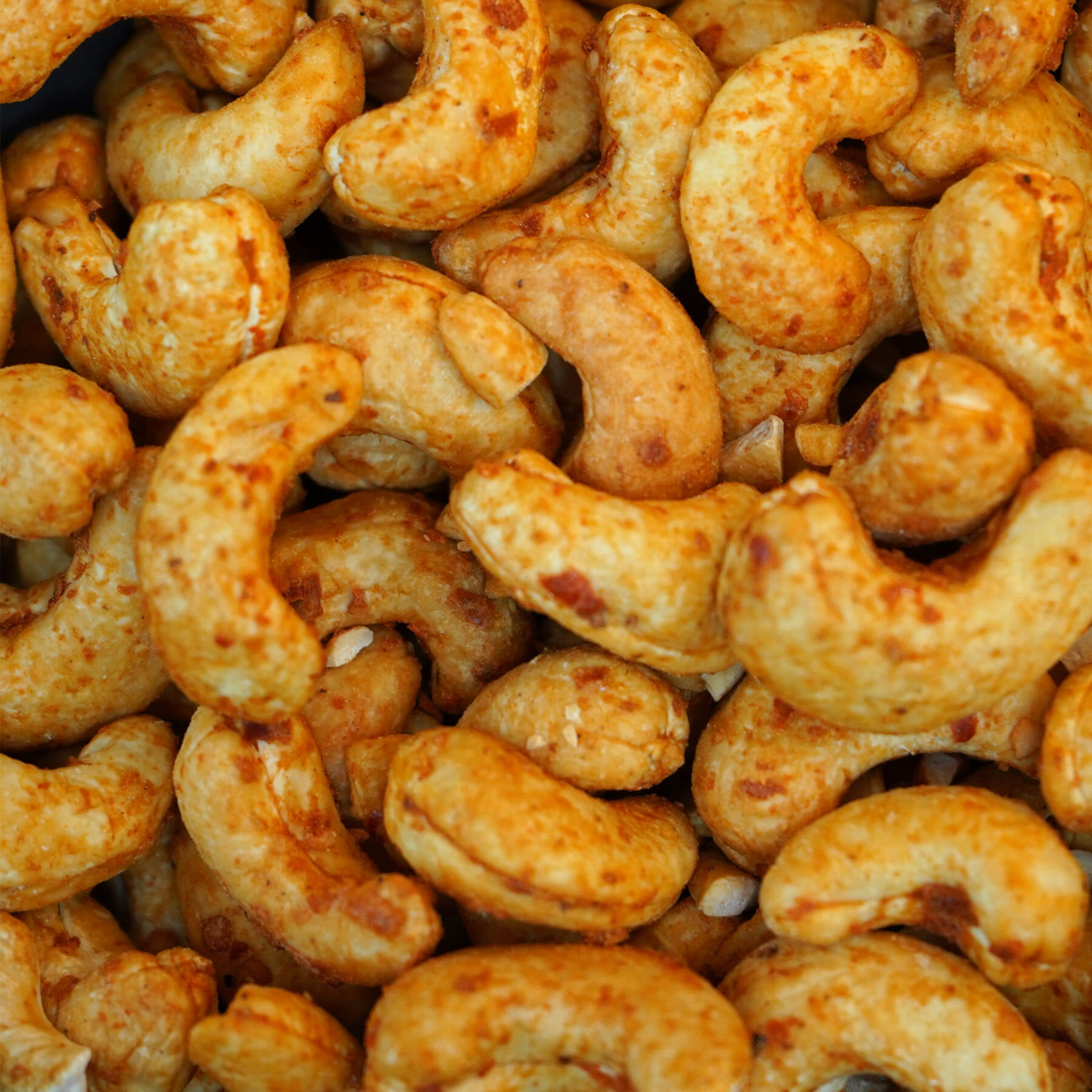 Nahaufnahme gerösteter Cashewkerne mit rotem Kampot Pfeffer