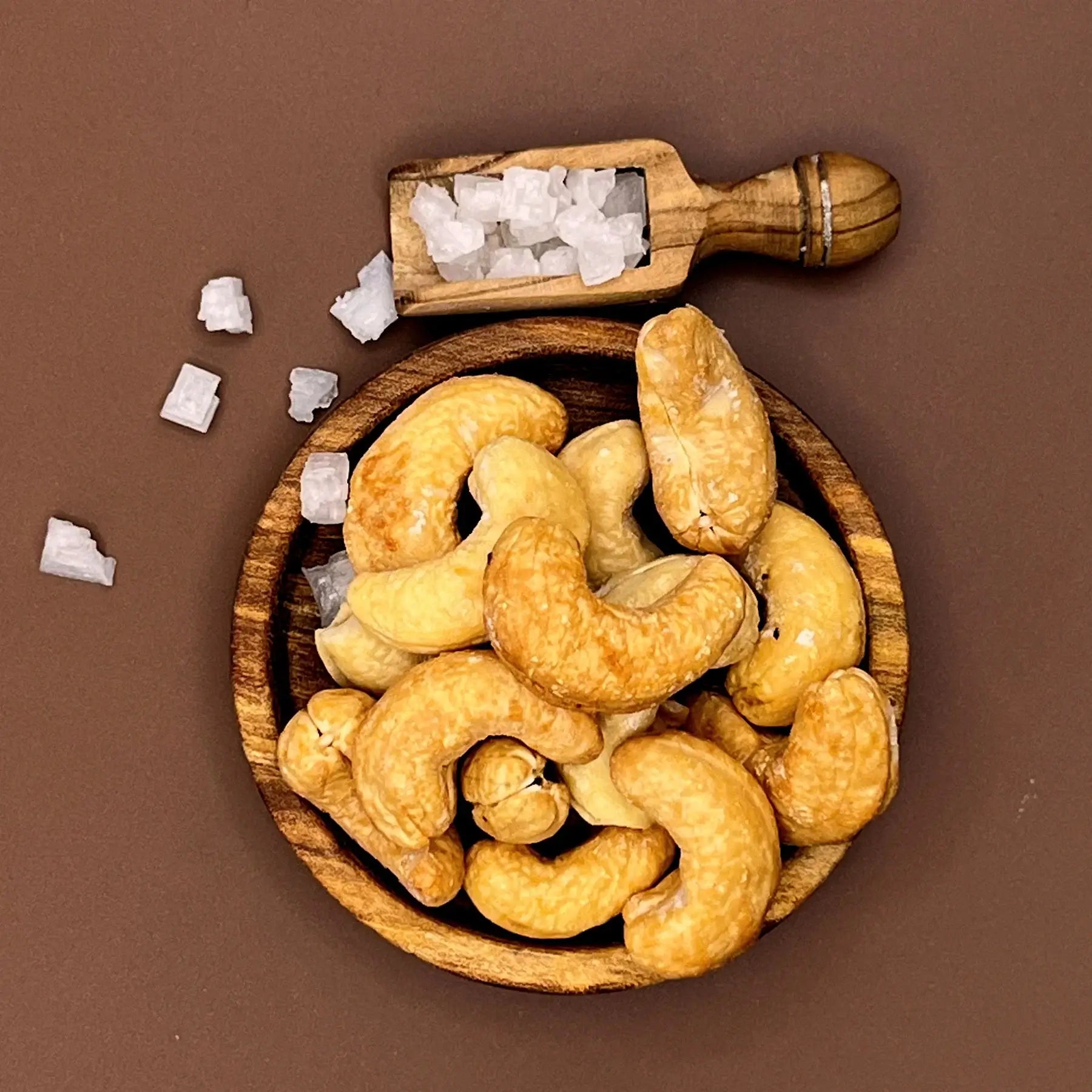 Geröstete Cashews mit Meersalz in einer Holzschale, daneben eine Salzschaufel